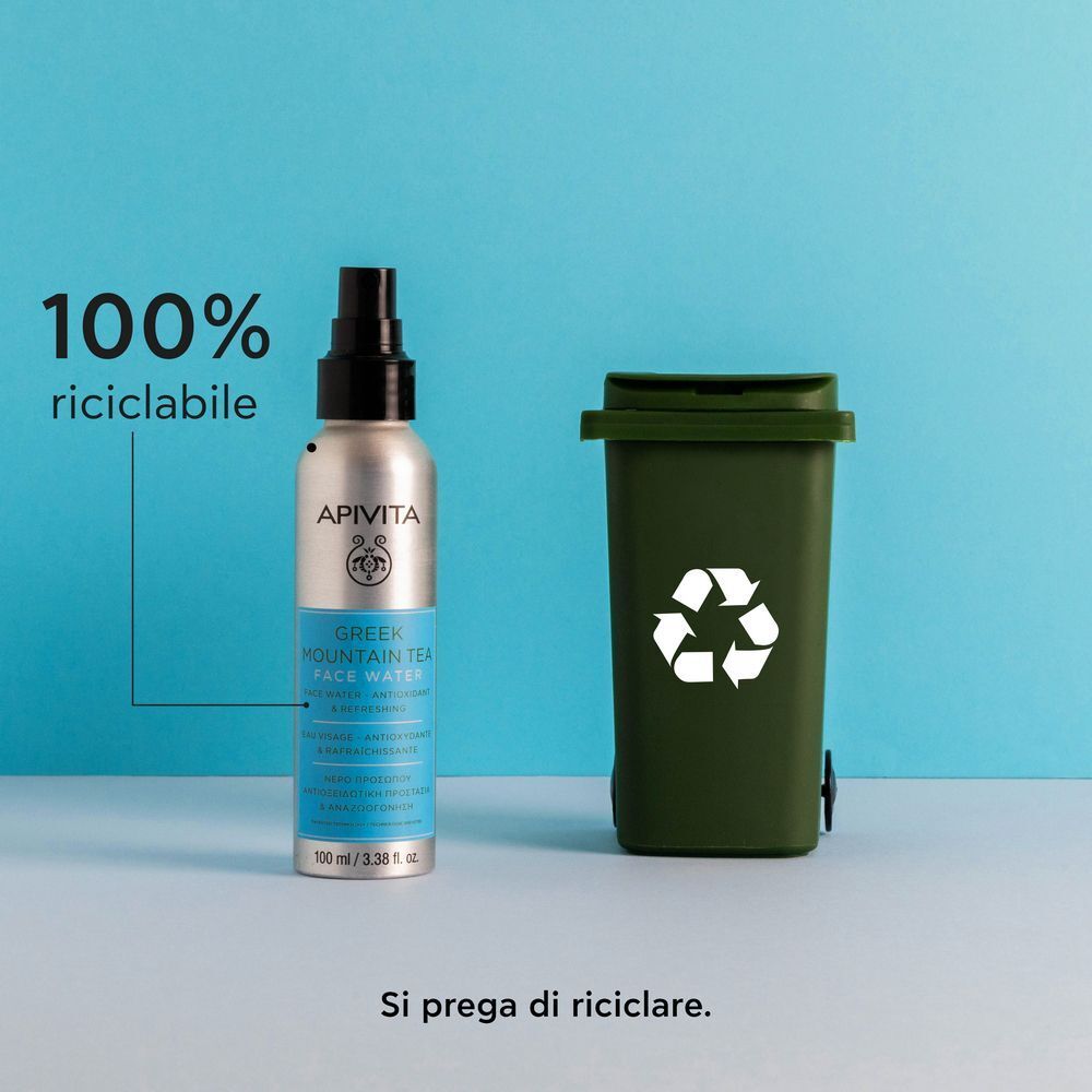 Acqua Viso APIVITA Tè Greco di Montagna accanto a un bidone per il riciclo.