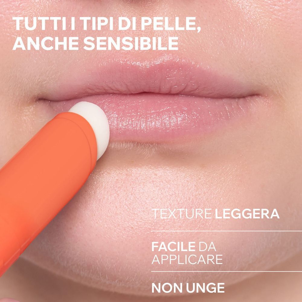 Primo piano di labbra su cui viene applicato uno stick solare.