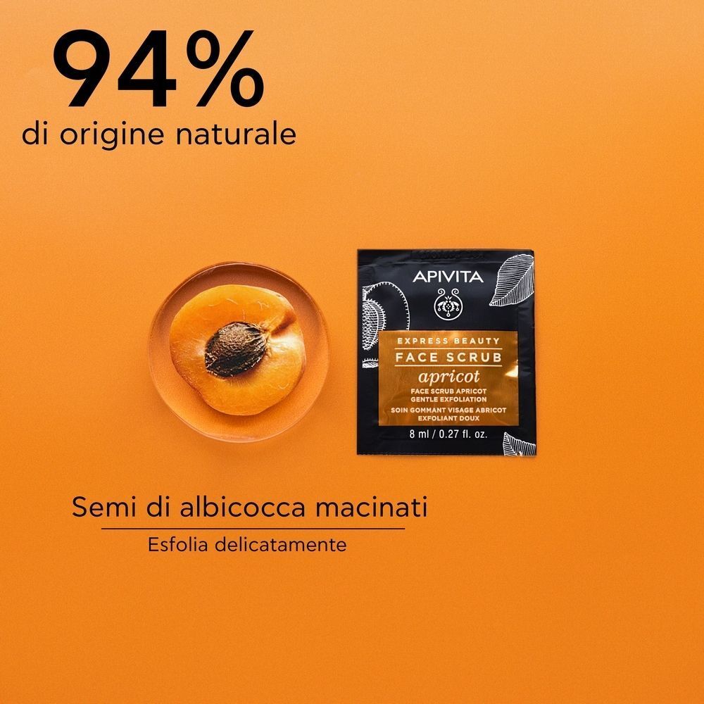 Una bustina APIVITA EXPRESS BEAUTY Scrub Viso con Albicocca accanto a mezzo albicocca.