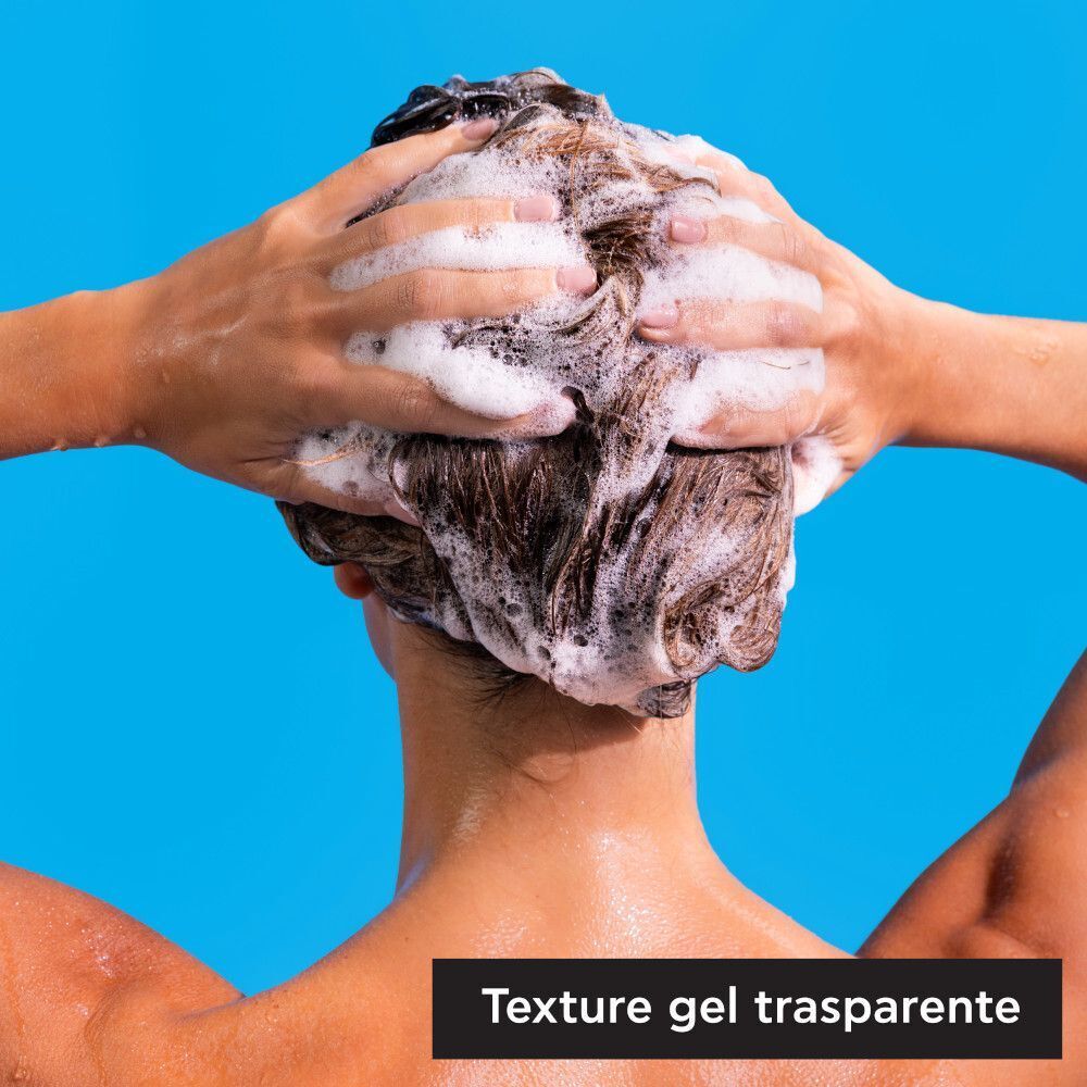Persona che si lava i capelli con schiuma.