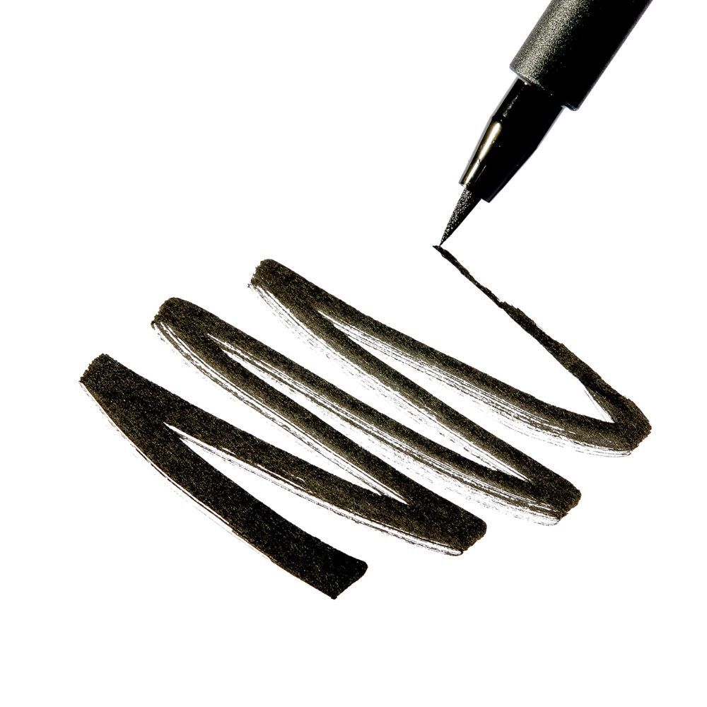 Primo piano della punta di un eyeliner nero che traccia una linea nera su sfondo bianco.