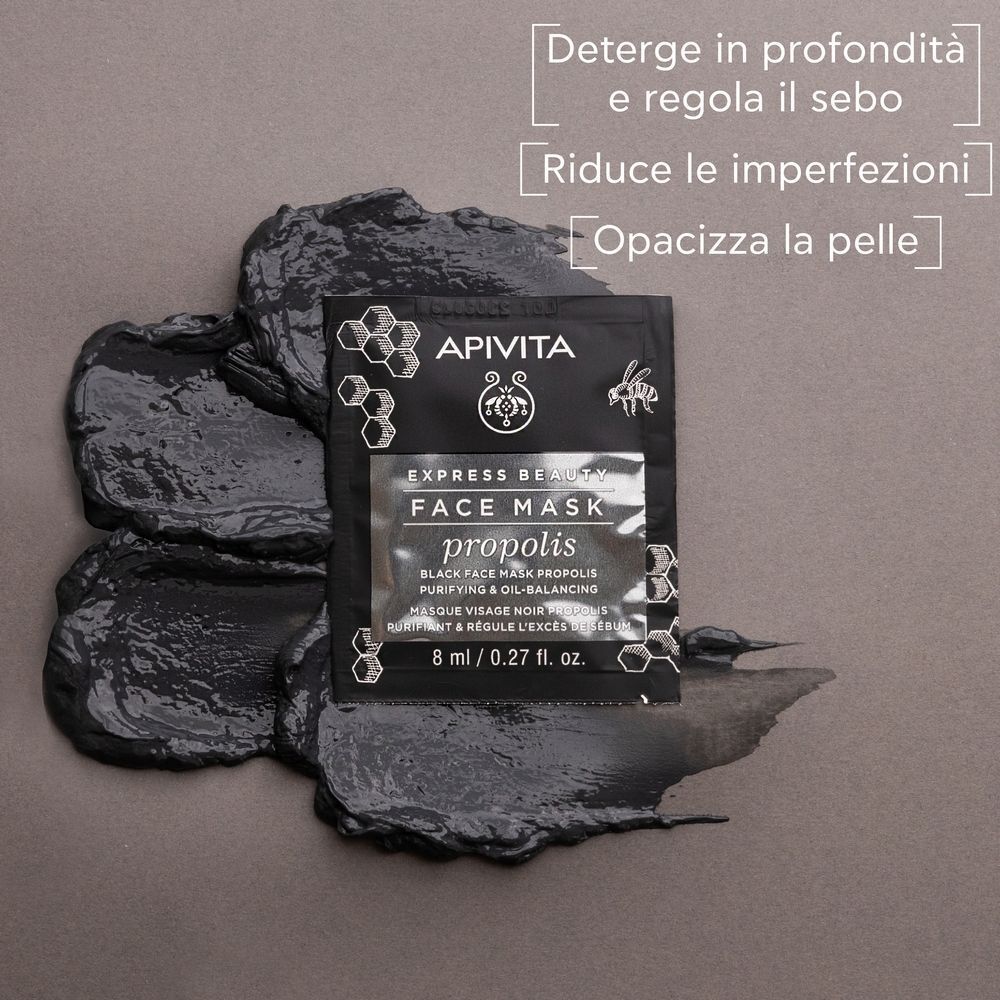 Una bustina APIVITA EXPRESS BEAUTY Maschera Viso Propoli accanto a maschera nera.