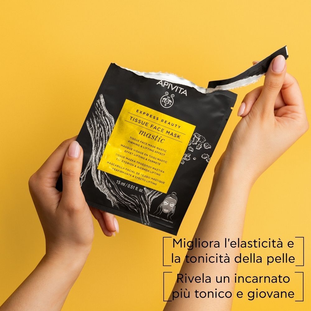 Mani che aprono la Maschera Viso Mastic APIVITA EXPRESS BEAUTY. Sacchetto nero con etichetta gialla.