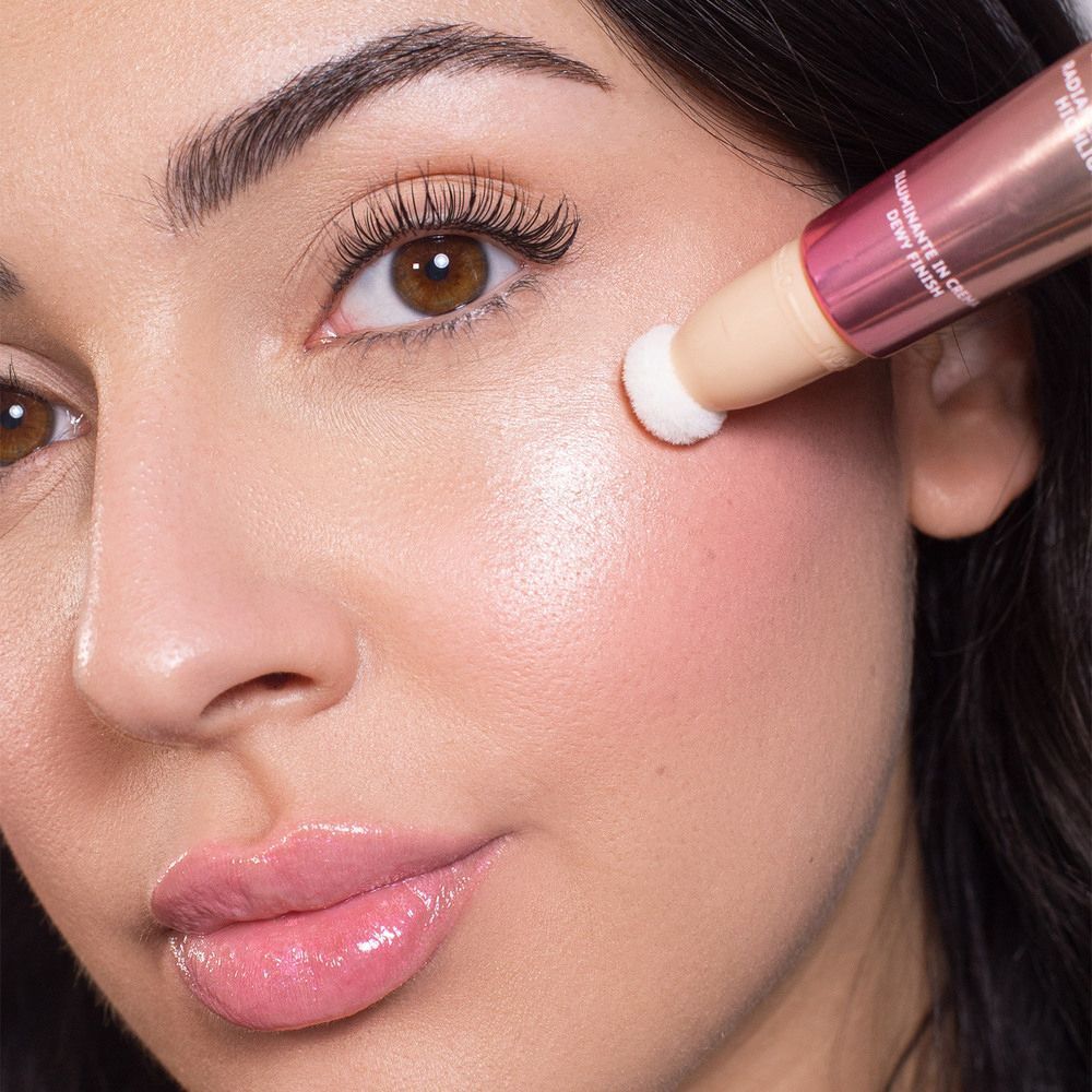 Una donna applica l'ASTRA Make-Up Light Therapy Illuminante Blush sulla guancia.