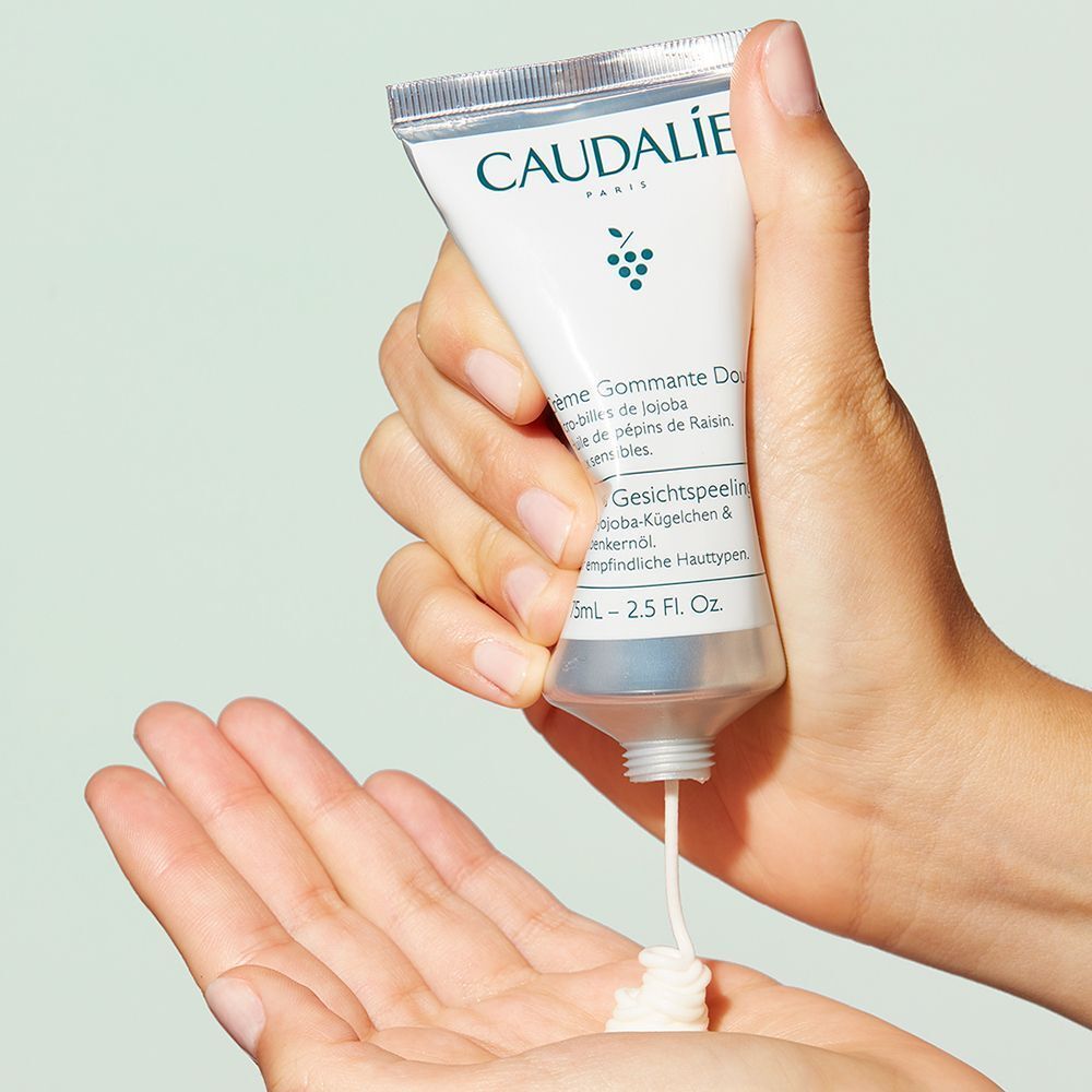 La Caudalie Gentle Buffing Cream viene spremuta da un tubetto nel palmo di una mano.