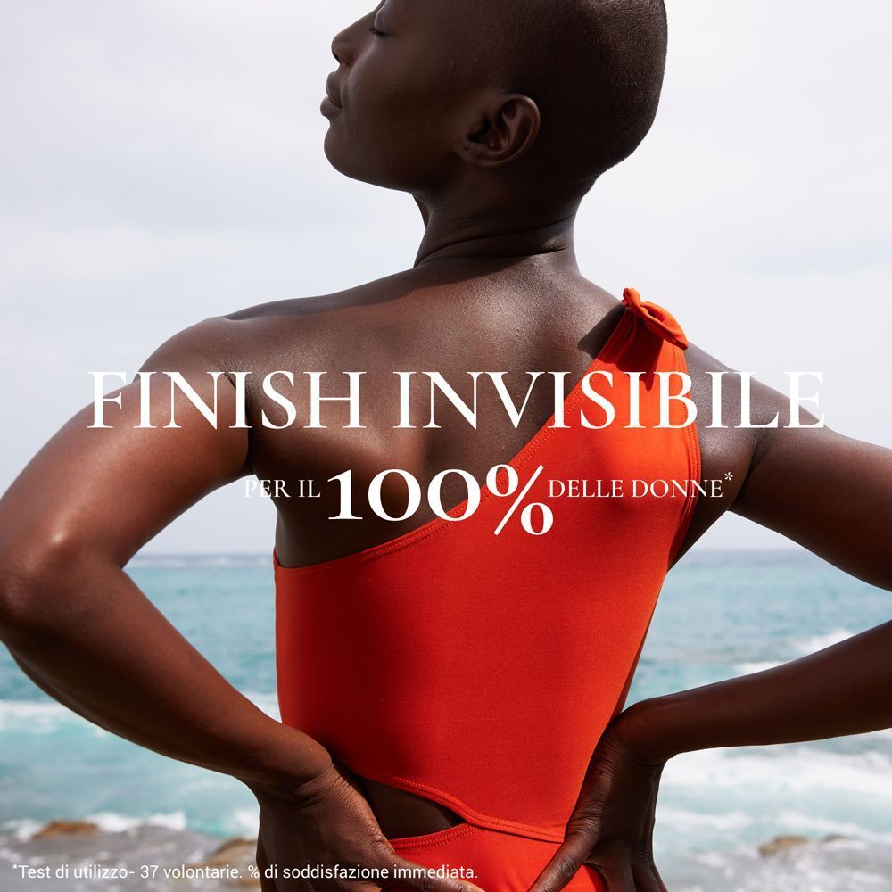 Donna in costume da bagno rosso sulla spiaggia. Finish invisibile per il 100% delle donne.