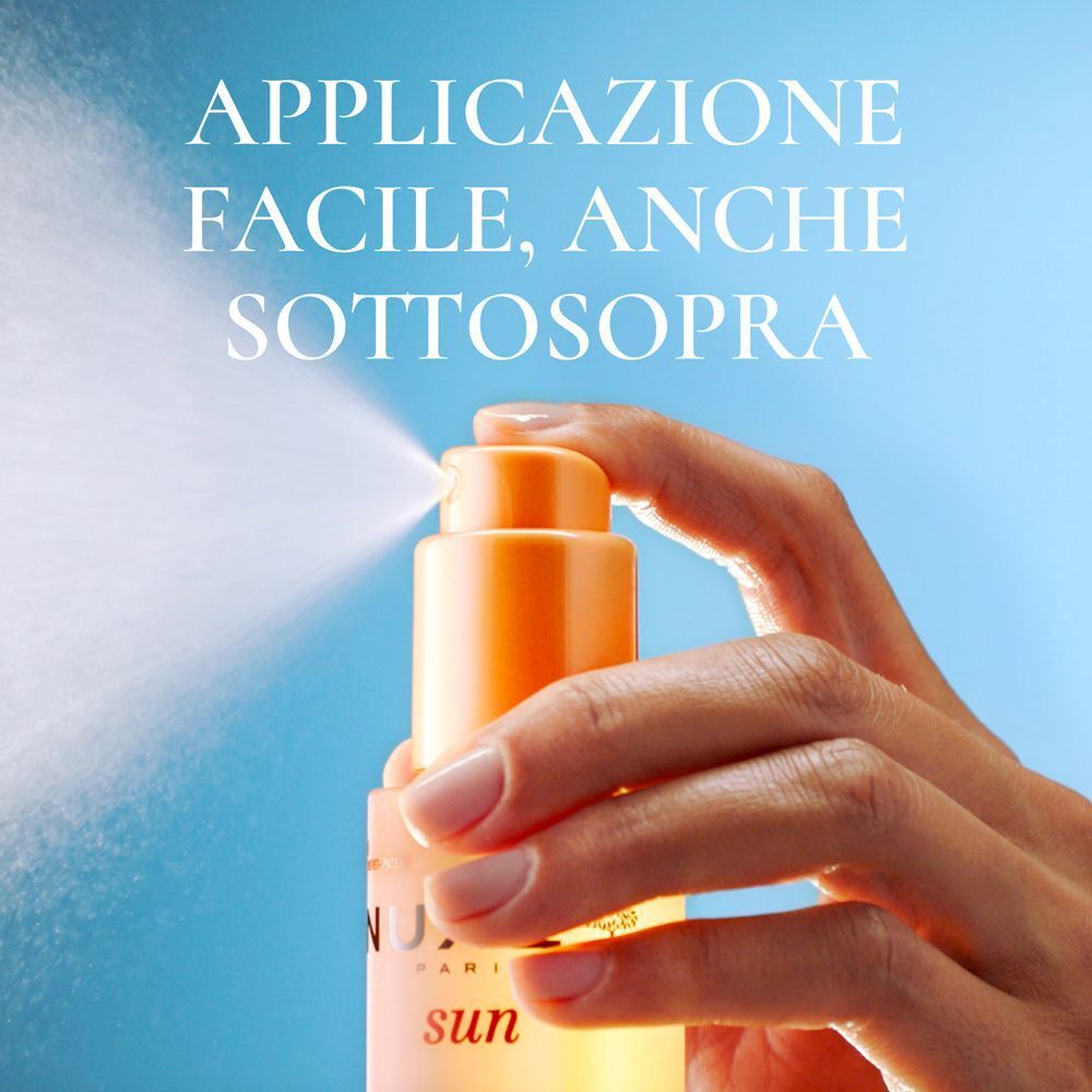 Mano che spruzza nebbia solare da una bottiglia, utilizzabile anche capovolta.
