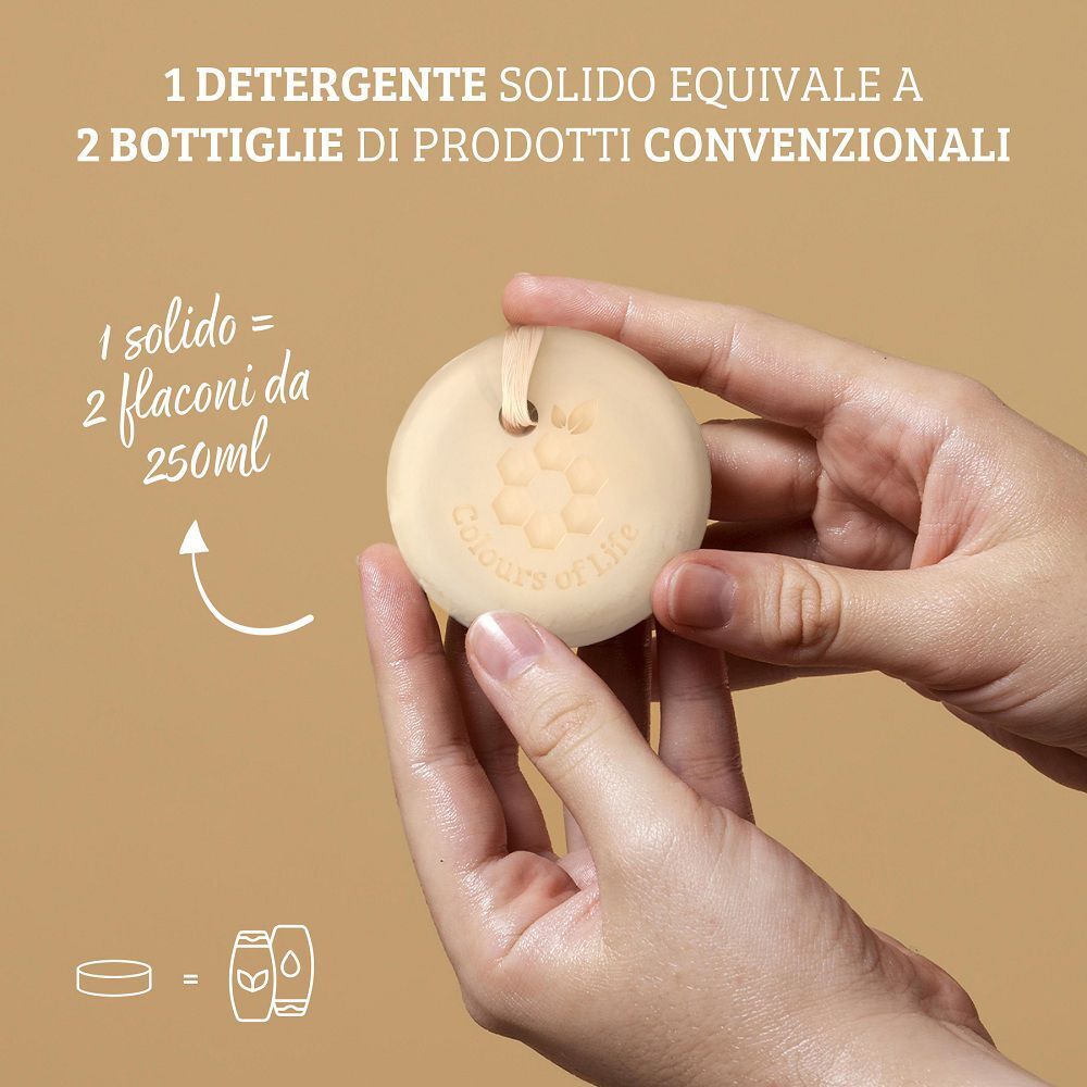 Mani che tengono una saponetta solida da doccia con cordino, accanto a un grafico che confronta 1 solido con 2 flaconi.