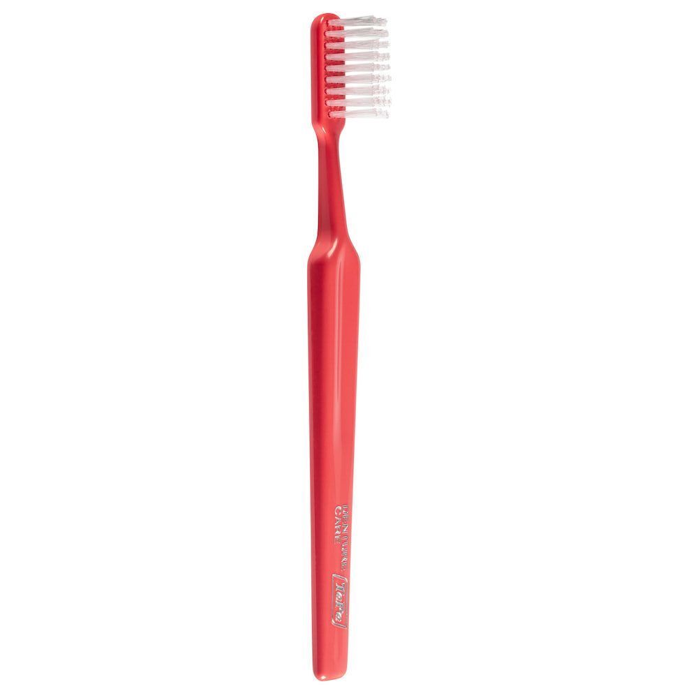 Uno spazzolino TePe Denture Care rosso. Setole morbide, manico ergonomico.
