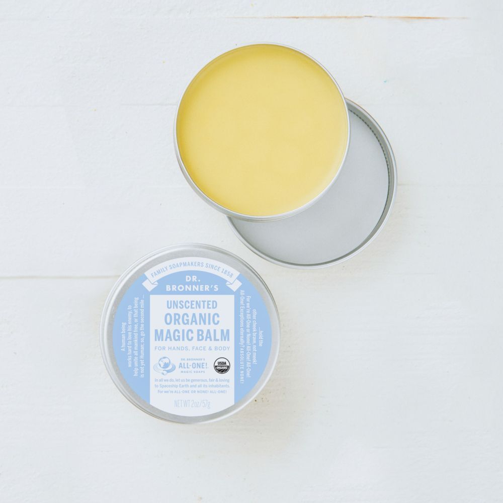 Una lattina aperta Dr. Bronner's Unscented Organic Magic Balm accanto alla lattina chiusa.