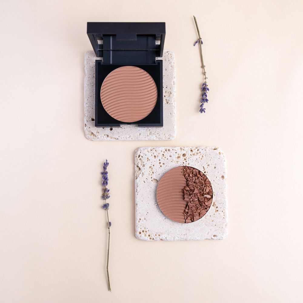 LEPO XLent Bronzer Terra, Nuance 11, aperto e un prodotto rotto, con rametti di lavanda.