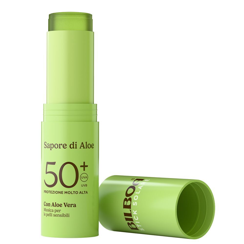 Uno stick solare verde aperto con SPF 50+ e Aloe Vera, il suo tappo accanto.