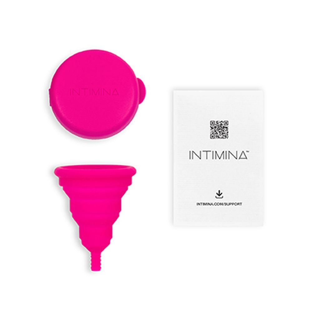 Contenitore rosa, una coppetta mestruale pieghevole e istruzioni INTIMINA.