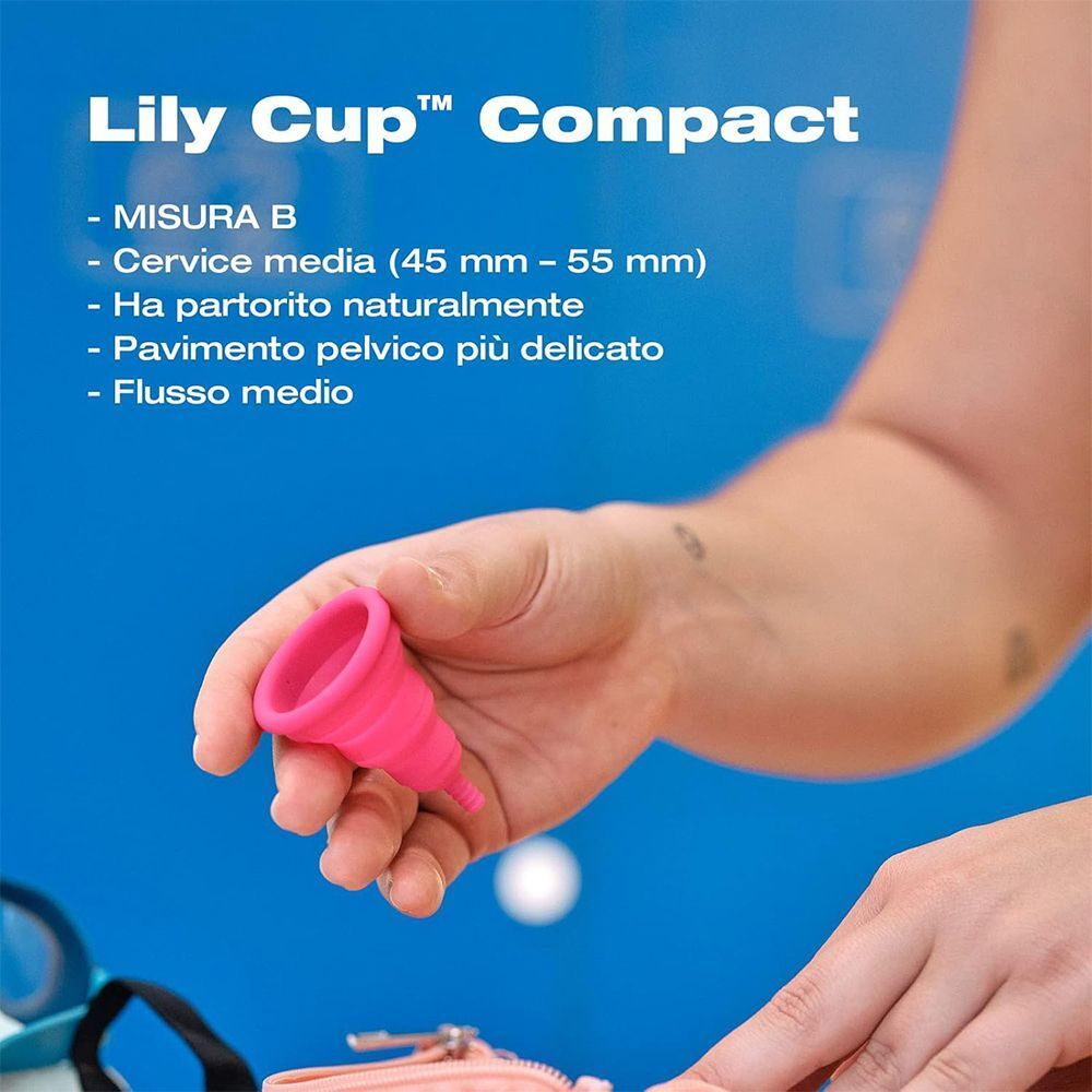 Mano che tiene una piccola coppetta mestruale pieghevole rosa.