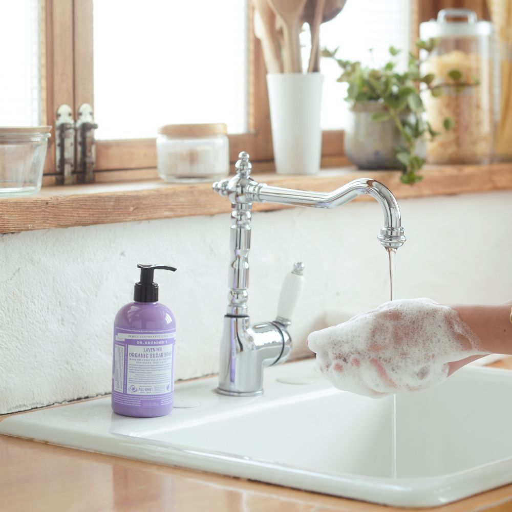 Sapone biologico allo zucchero Dr. Bronner's Lavanda vicino a un lavandino con mani schiumose.
