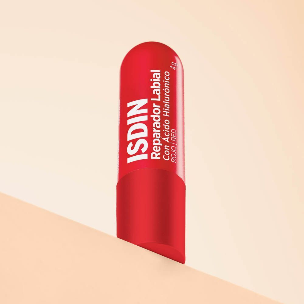 Uno stick ISDIN balsamo labbra rosso con acido ialuronico, su una superficie inclinata.