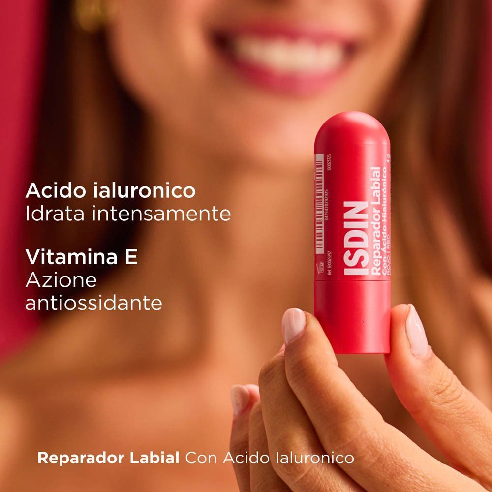 Una mano tiene uno stick ISDIN balsamo labbra rosso con acido ialuronico.