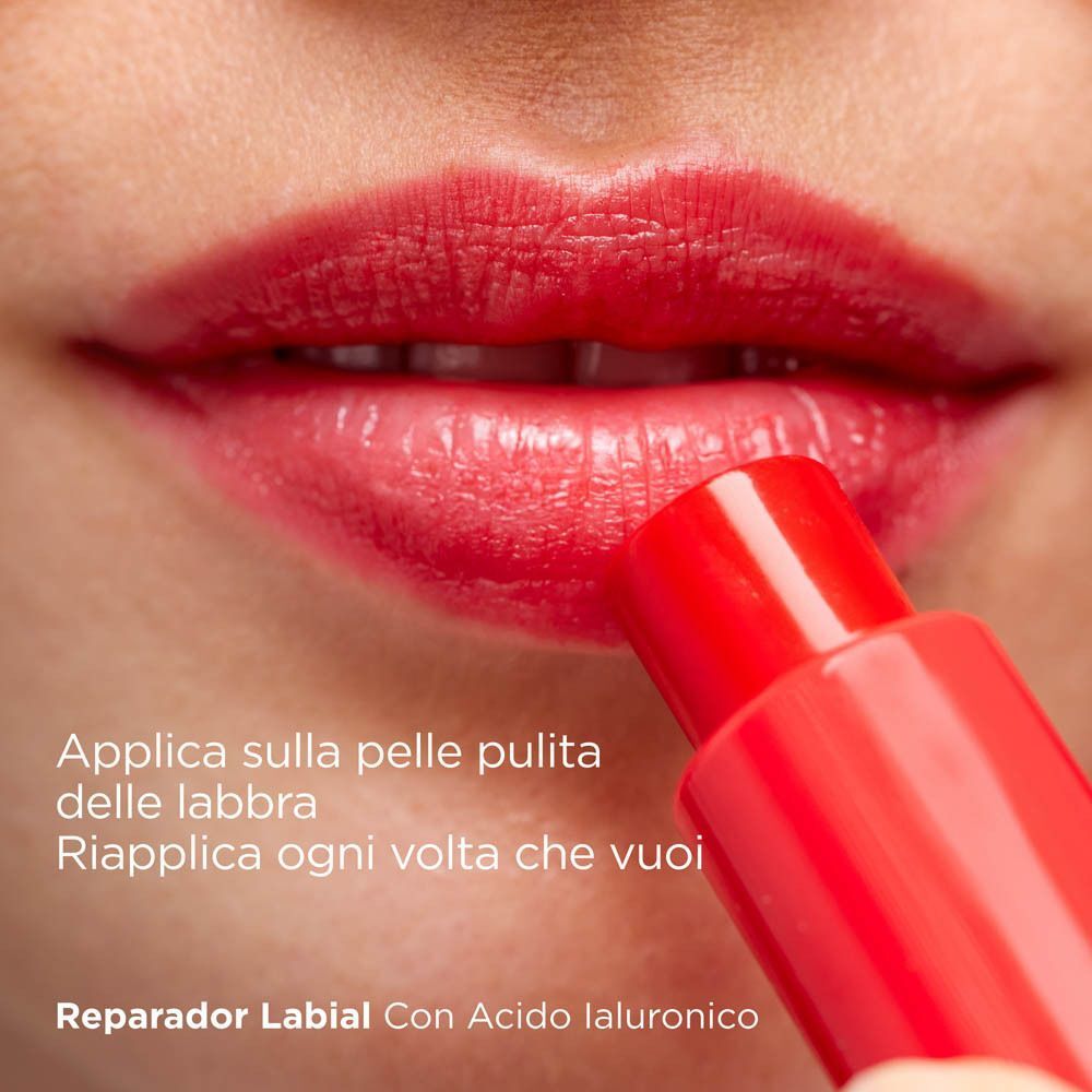 Primo piano di labbra a cui viene applicato uno stick balsamo labbra rosso.