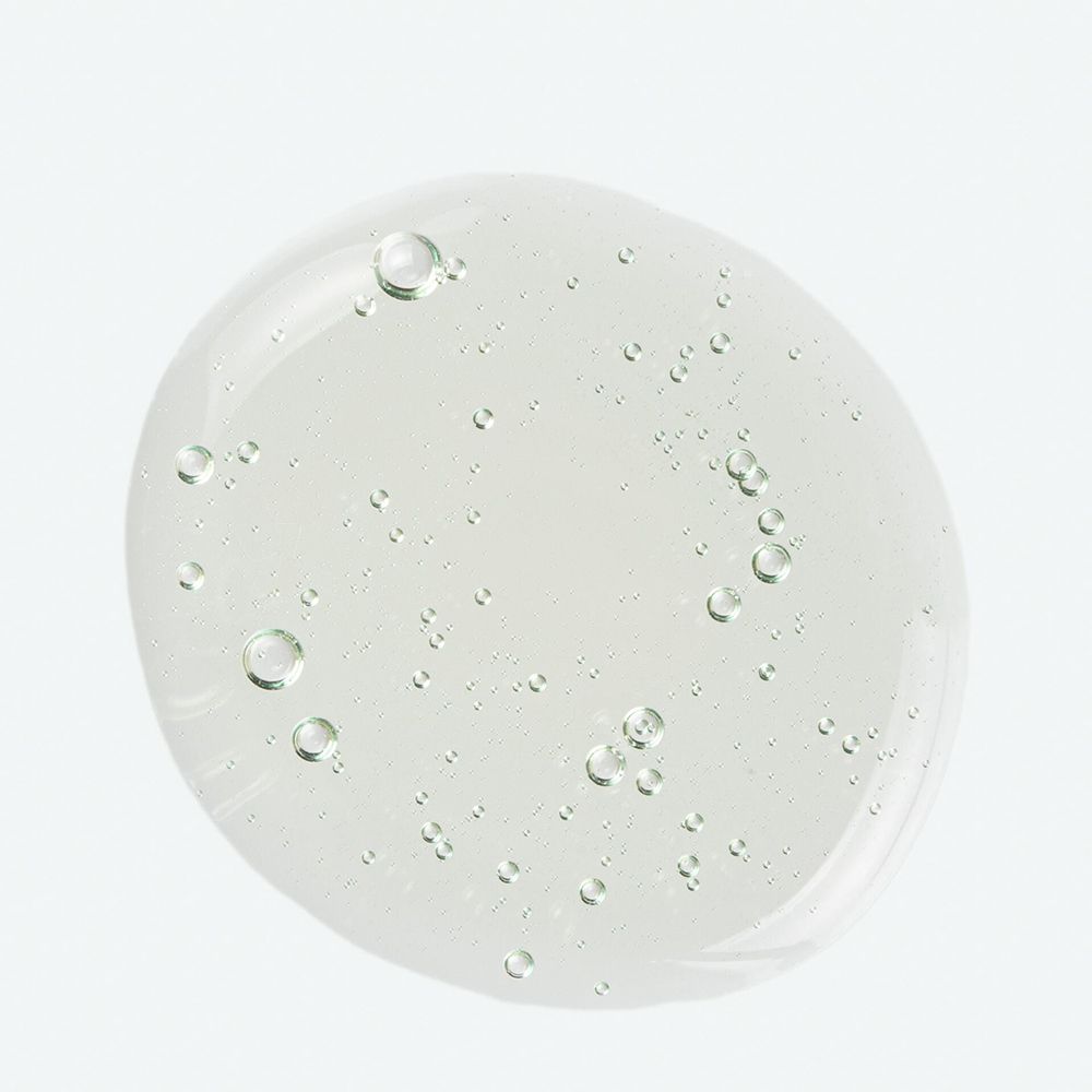 Liquido trasparente ovale con piccole bolle. Su sfondo chiaro.