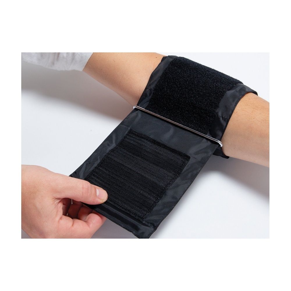 Braccio con bracciale nero. Bracciale con chiusura a strappo. Mano che fissa il bracciale.