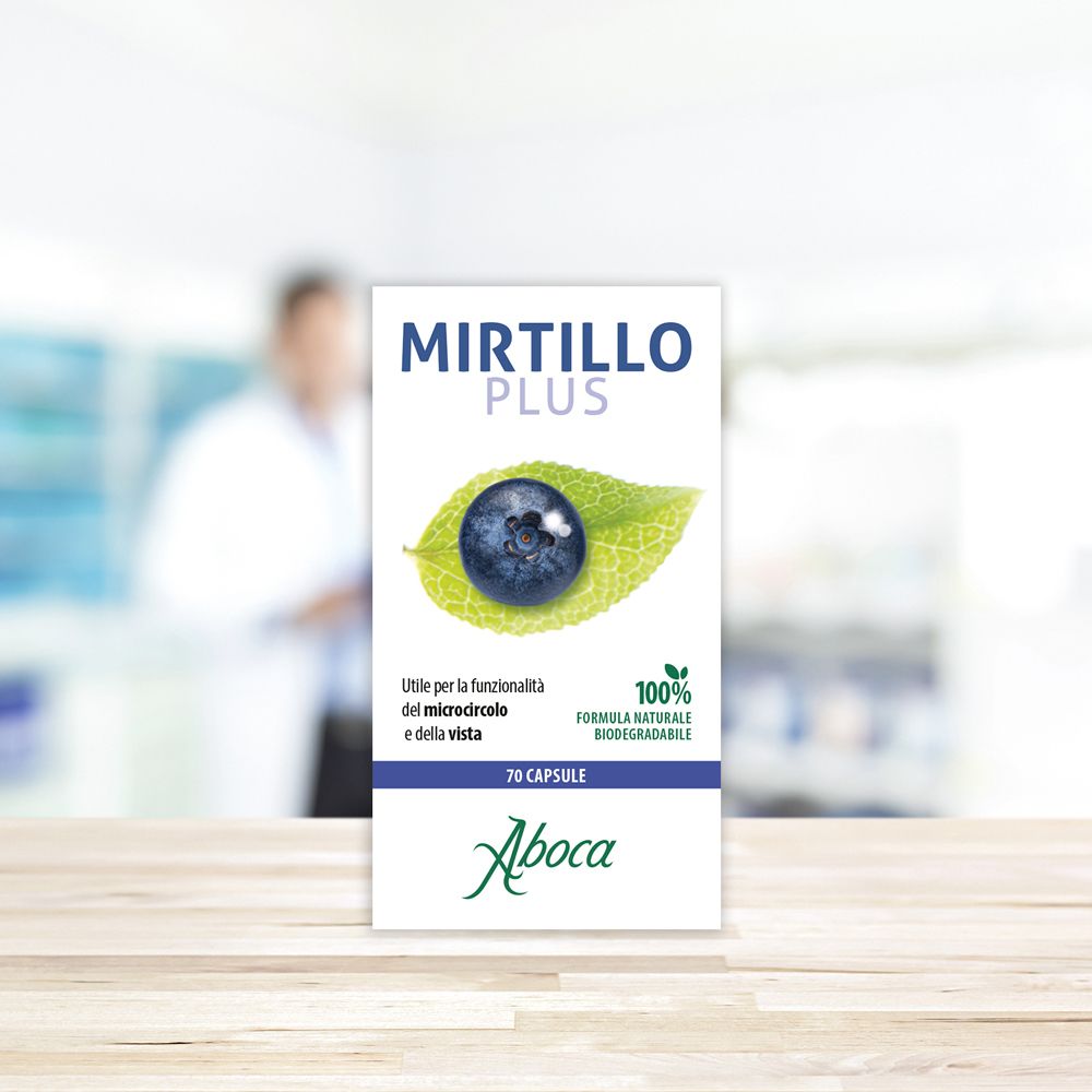 Confezione Mirtillo Plus. Mirtillo su foglia. 70 capsule. Logo Aboca. Formula naturale al 100%. Sfondo sfocato.