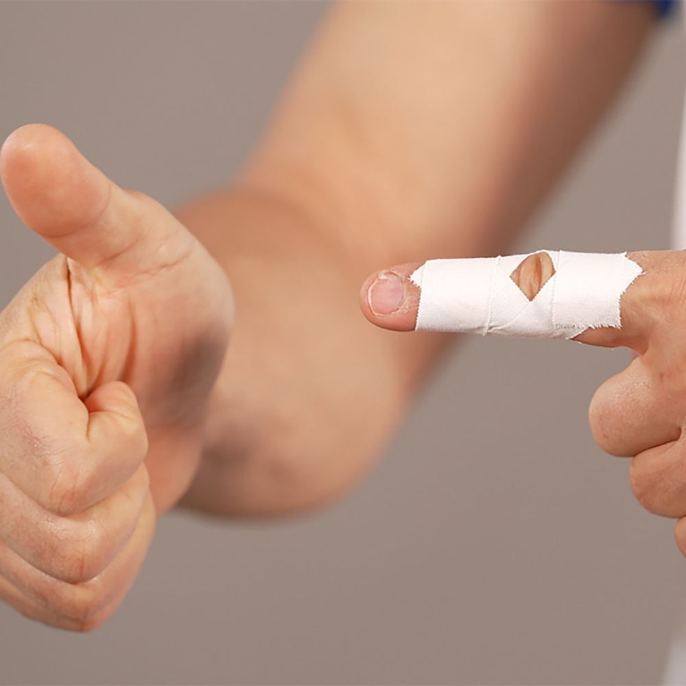 Dito bendato con Leukotape Classic. Pollice in su come gesto.