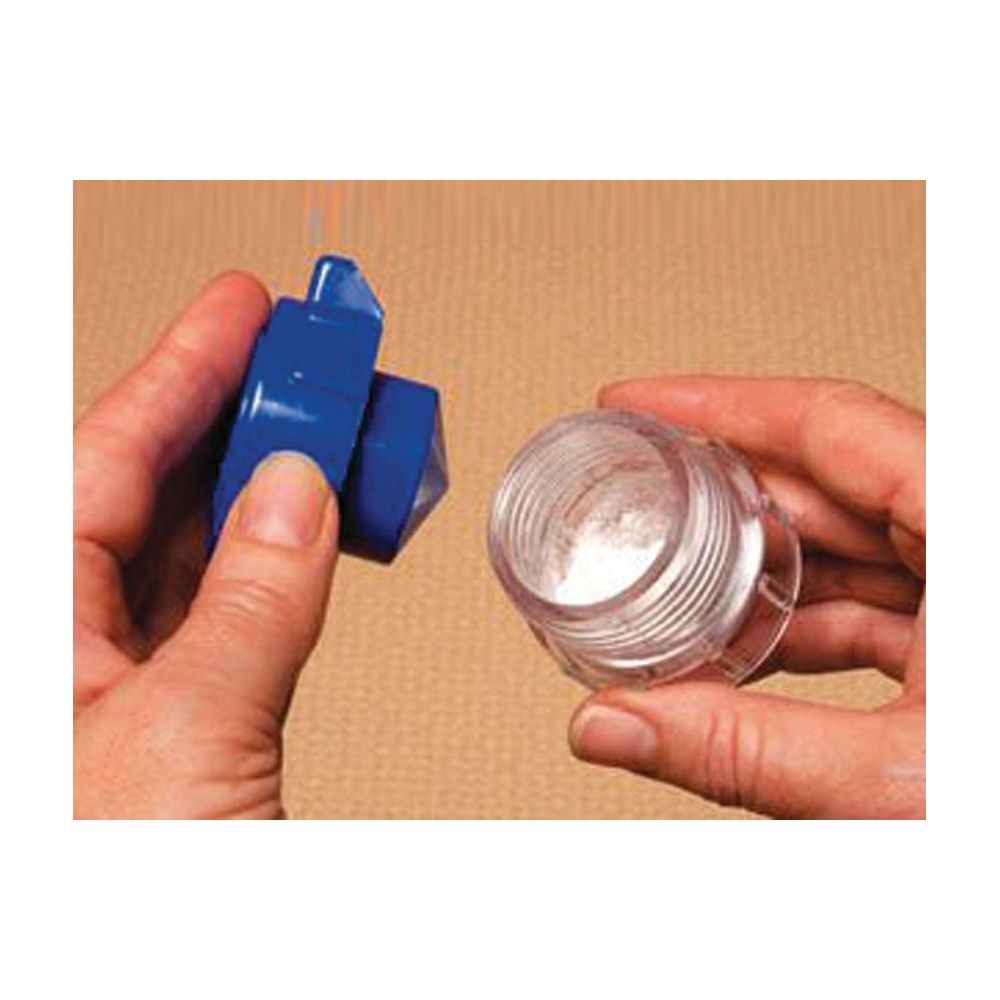 Mani che tengono coperchio blu e cappuccio trasparente con polvere bianca. Prodotto in uso.