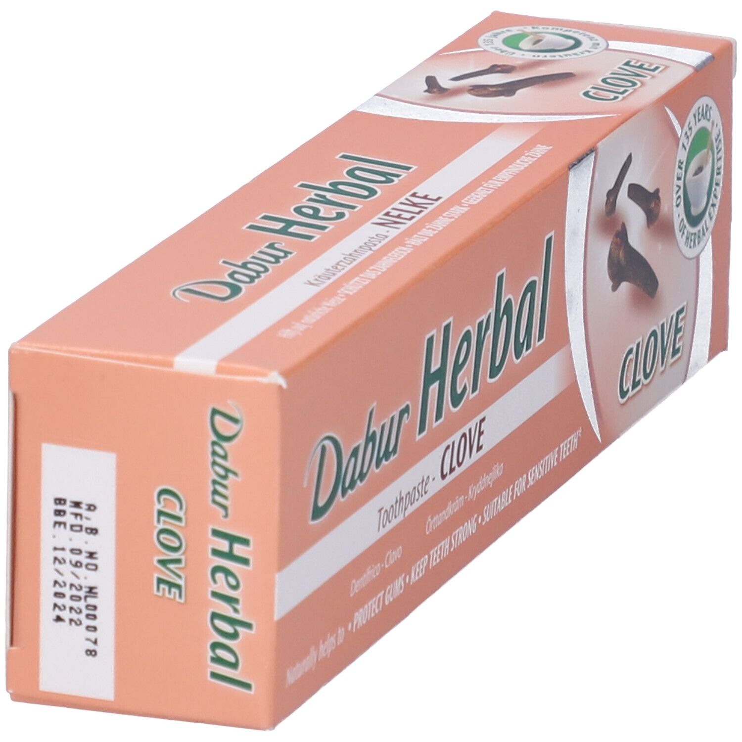 Confezione di dentifricio obliqua. Testo: Dabur Herbal, Clove. Sigillo verde: 125 anni di esperienza. Data di scadenza stampata.
