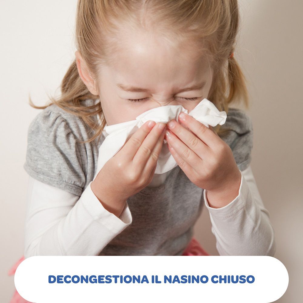 Bambina si soffia il naso con un fazzoletto. Testo: DECONGESTIONA IL NASINO CHIUSO.