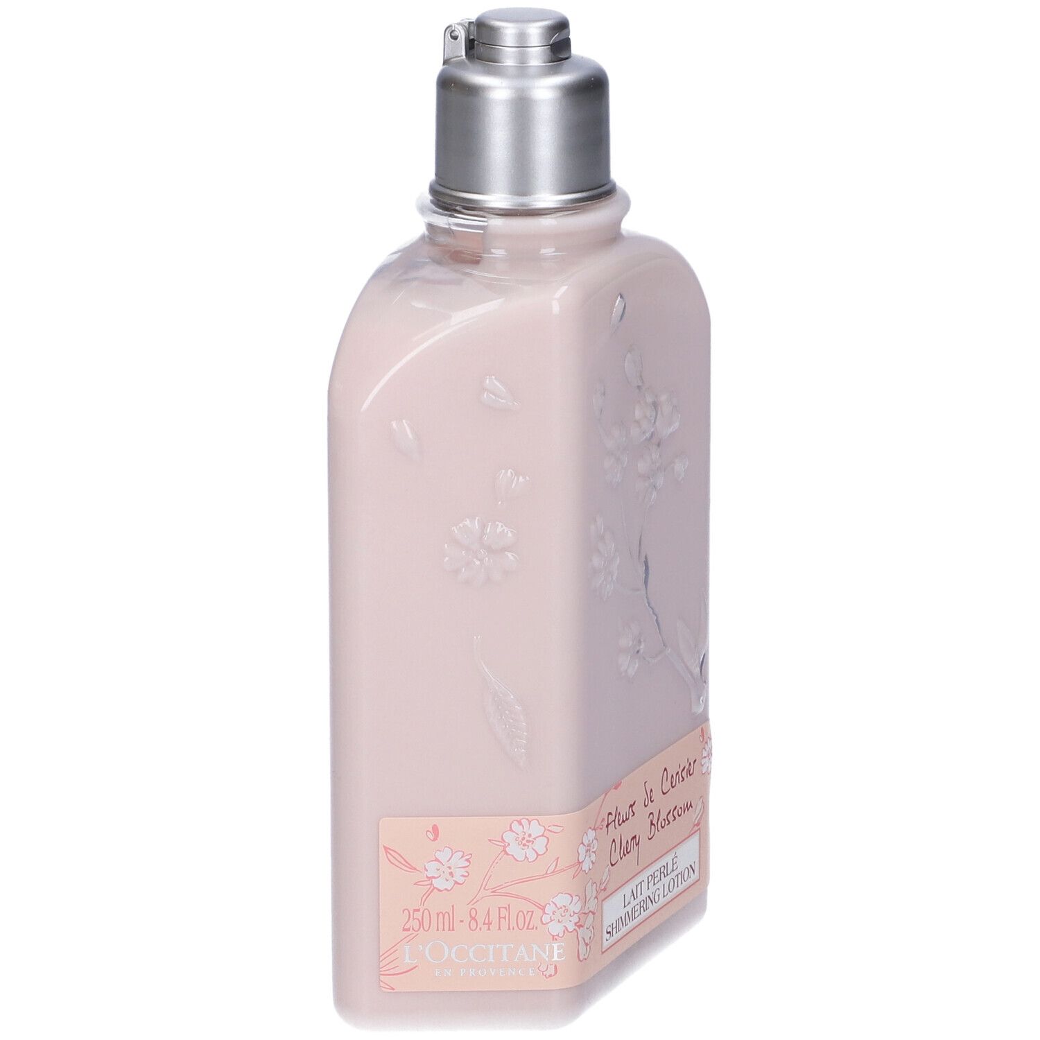 Flacone rosa con tappo argentato. Rilievo floreale ed etichetta con testo. L'Occitane.