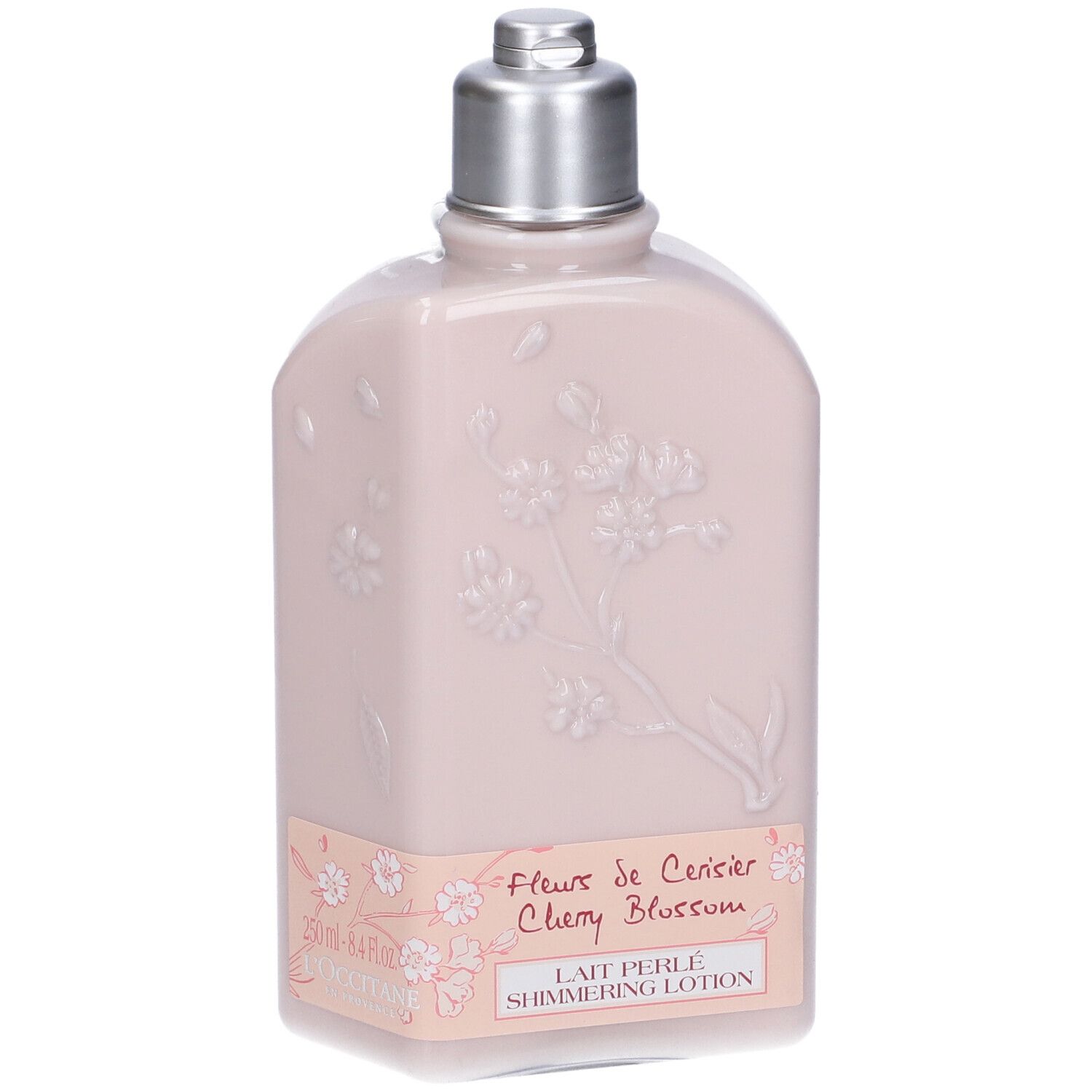 Flacone rosa con tappo argentato. Rilievo floreale ed etichetta con testo. L'Occitane.