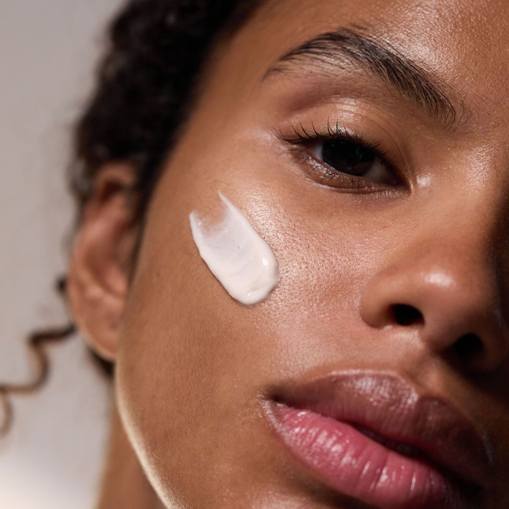 Primo piano di un viso con maschera sulla pelle. Crema sulla guancia.