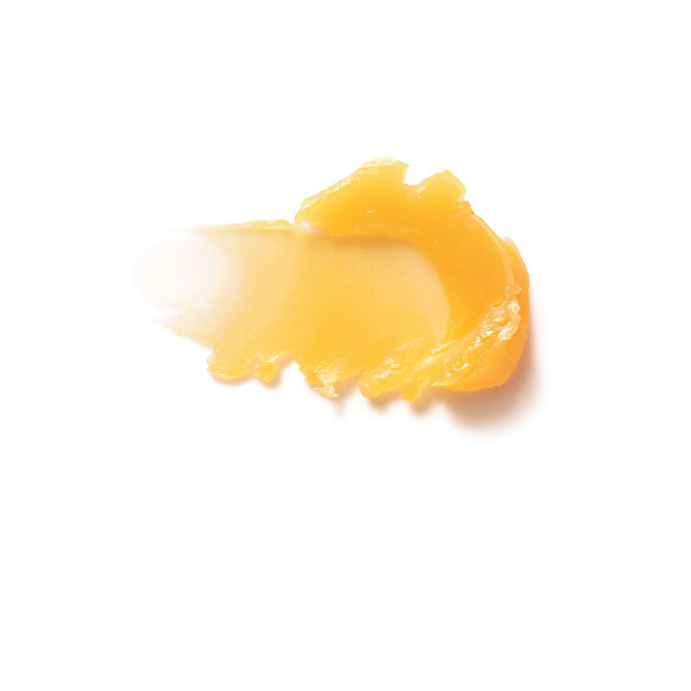 Texture gialla per la cura delle labbra su sfondo bianco. Consistenza: cremosa.