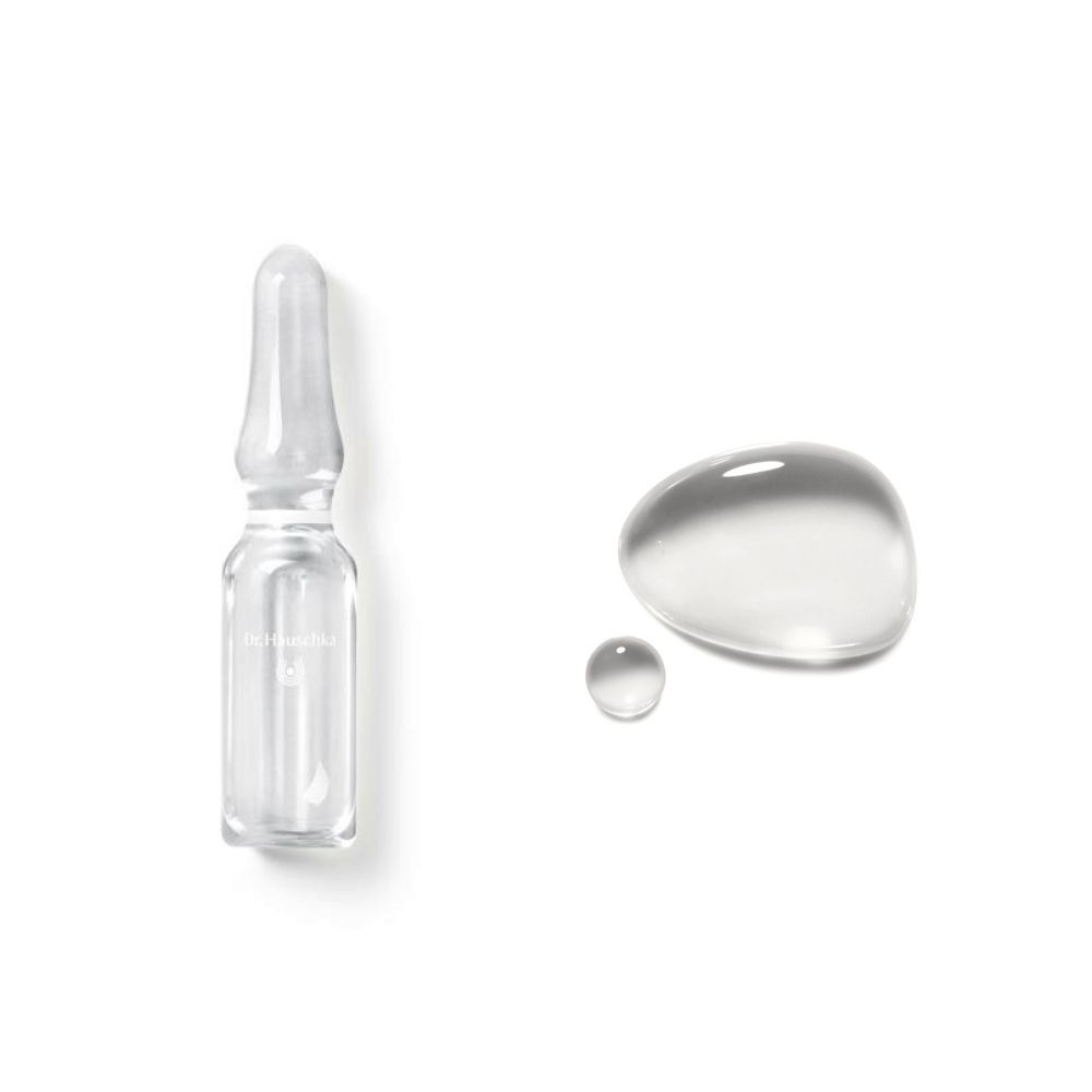 Fiala di vetro trasparente e due gocce di liquido su sfondo bianco.