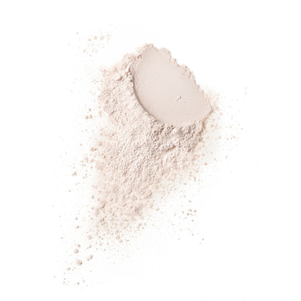 Mucchio di polvere chiara su sfondo bianco. Alcune particelle di polvere sparse.