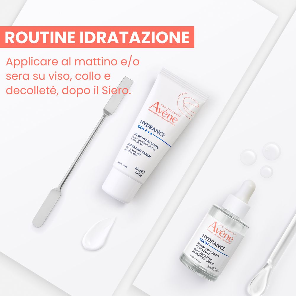 Crema idratante e siero concentrato Avene Hydrance su sfondo bianco con spatole e gocce d'acqua.