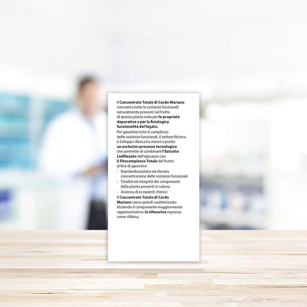 Retro della confezione del prodotto con testo. Scritto: Cardo Mariano, istruzioni per l'uso, 100% naturale. Sfondo: farmacia.