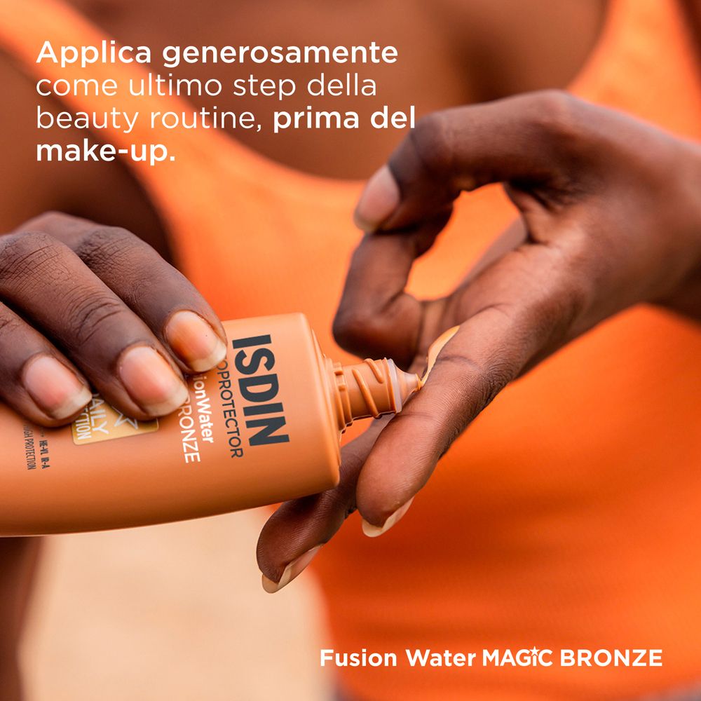 Donna che applica la crema solare. ISDIN, Fusion Water, Magic Bronze. Applicazione prima del trucco.