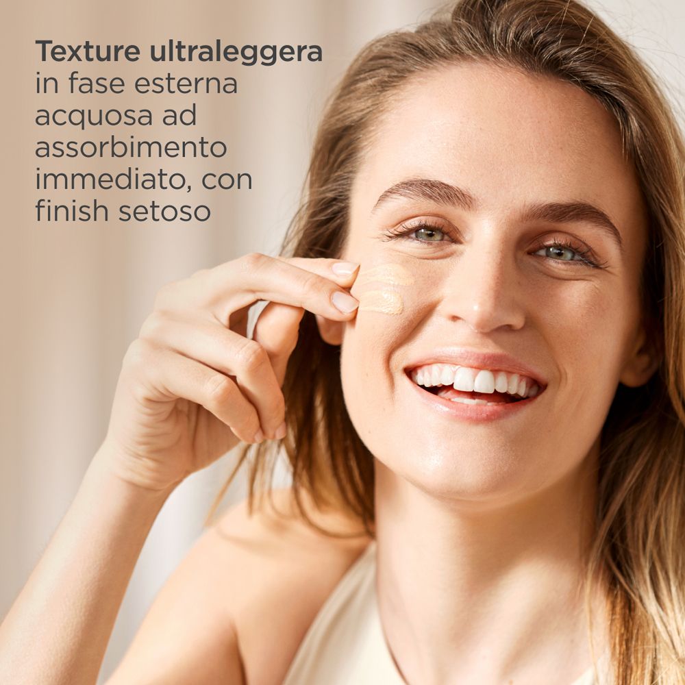 Donna applica ISDIN Fusion Water Magic Light SPF50. Testo: texture ultraleggera, assorbimento immediato.