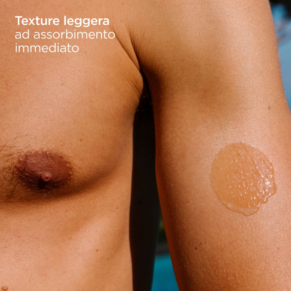 Primo piano di un uomo con protezione solare sul braccio. Testo: Texture leggera ad assorbimento immediato.