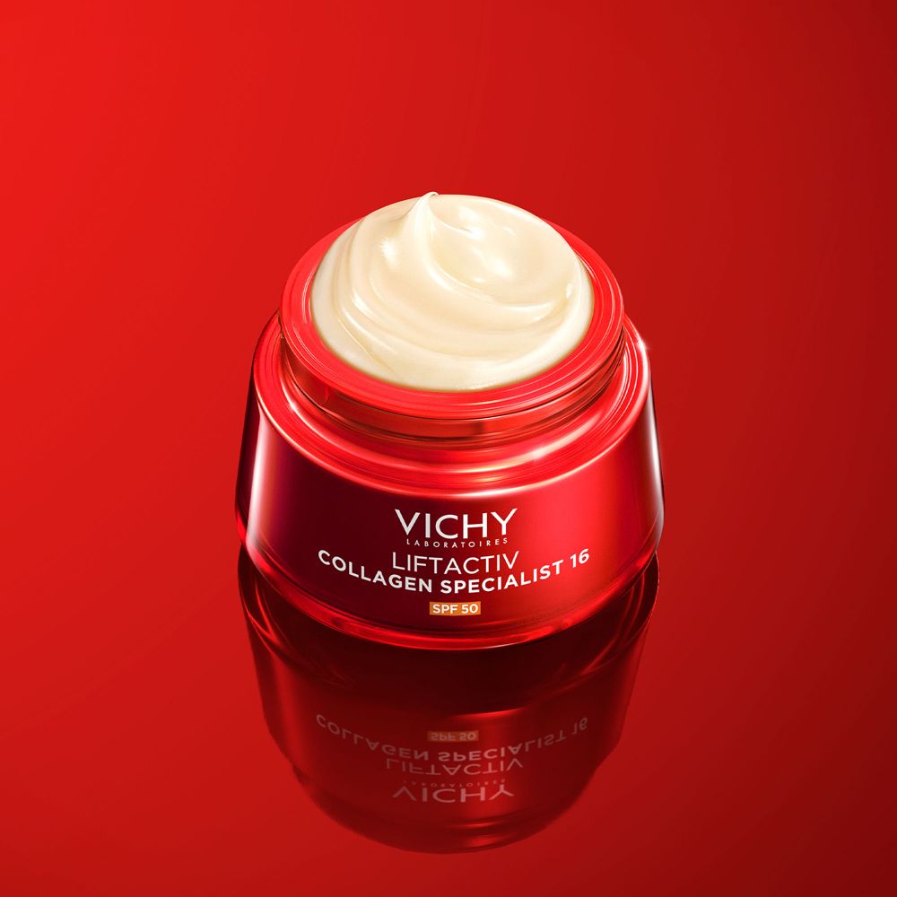 Vaso di crema rosso aperto con crema bianca. Vichy Liftactiv Collagen Specialist 16 SPF50. Sfondo rosso.
