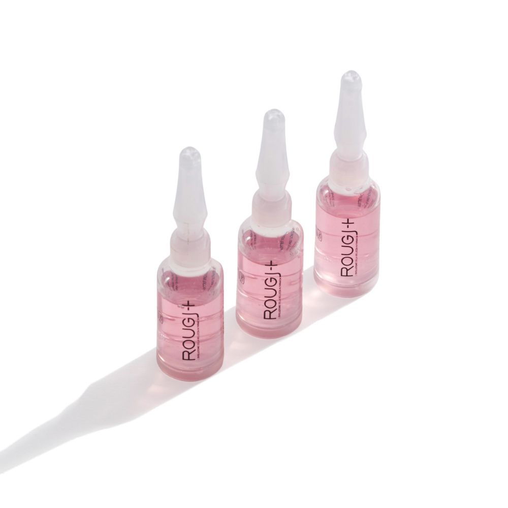 Tre fiale Rougj+ Fiale Anti-Caduta. Liquido trasparente in fiale di vetro con tappo bianco.