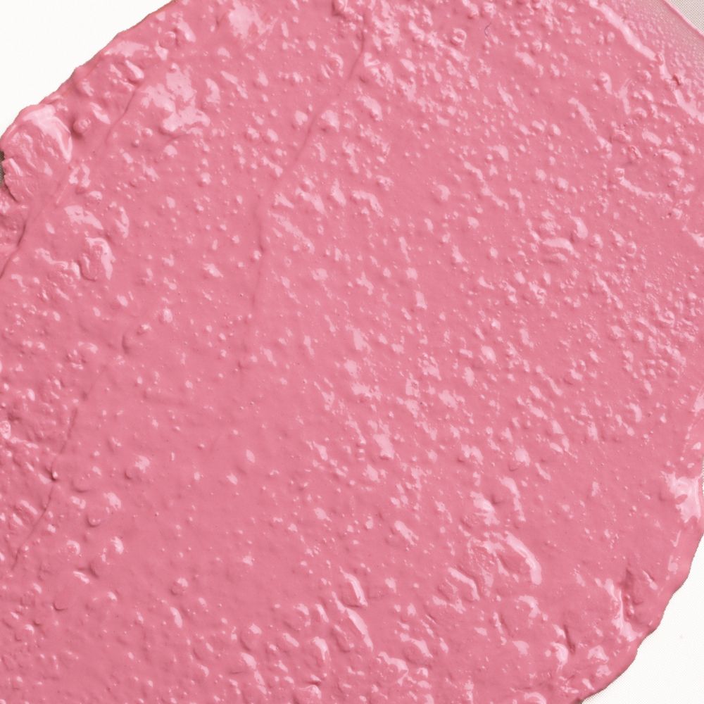 Primo piano della texture di un rossetto rosa. La texture è irregolare e ha una superficie lucida.