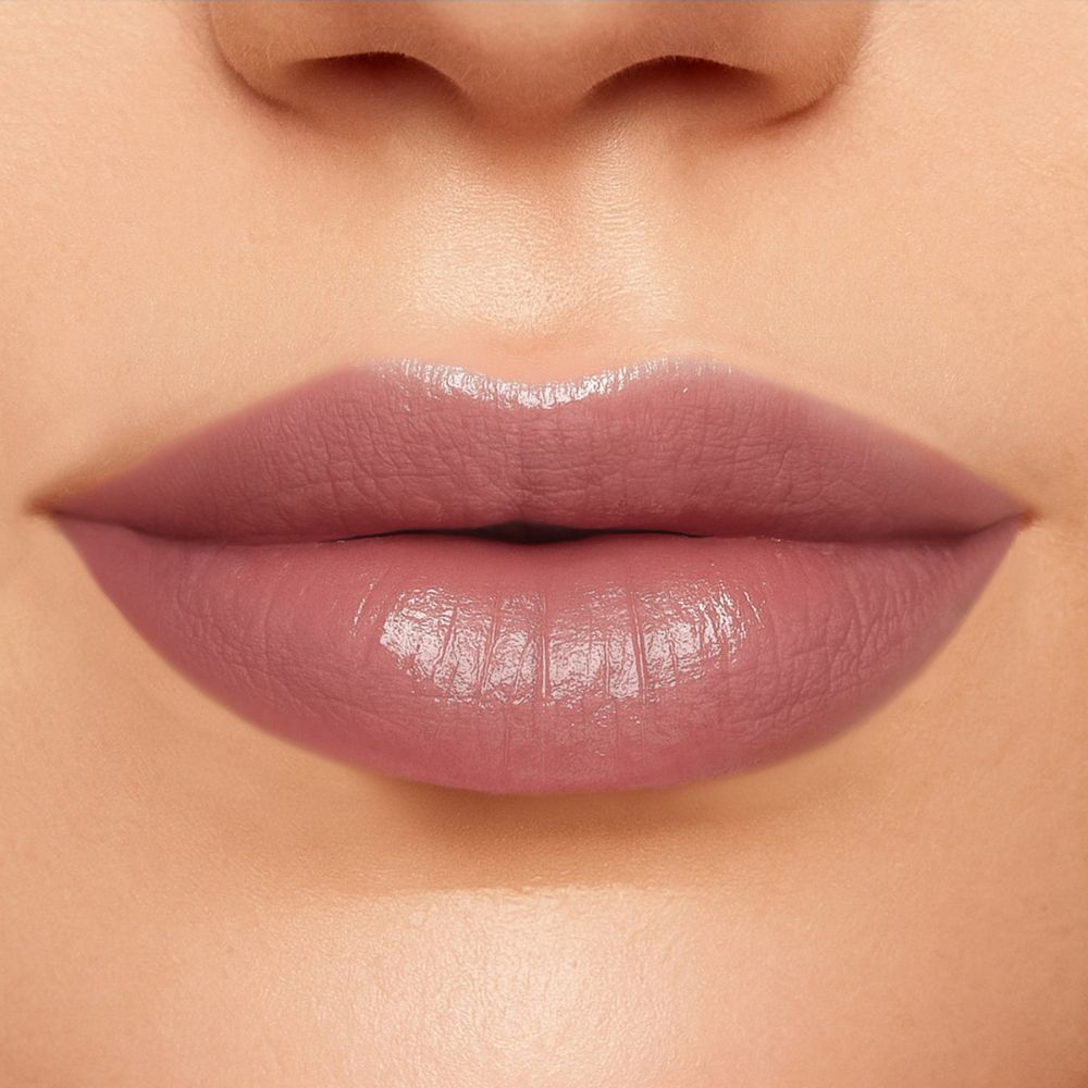 Primo piano di labbra truccate con un rossetto rosa. Le labbra sono lucide.