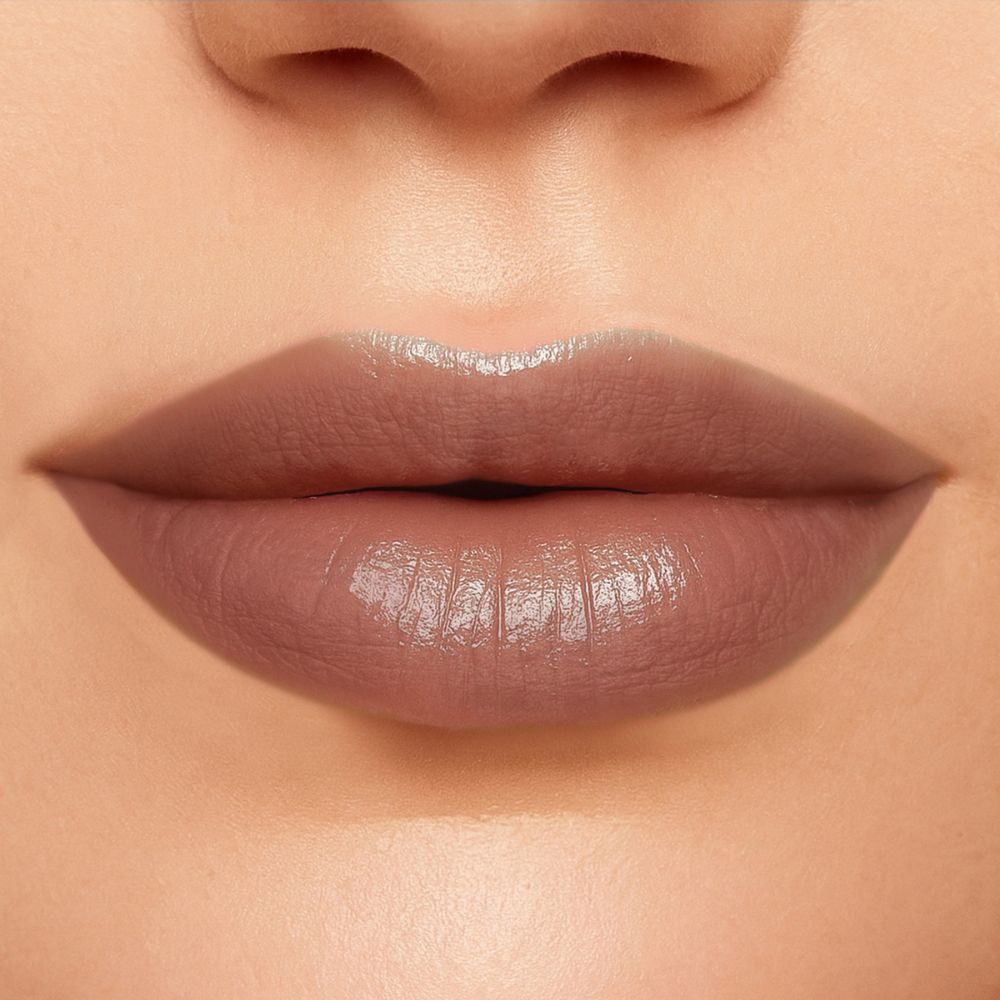 Primo piano di labbra dipinte con un rossetto rosa. Le labbra sono lucide.