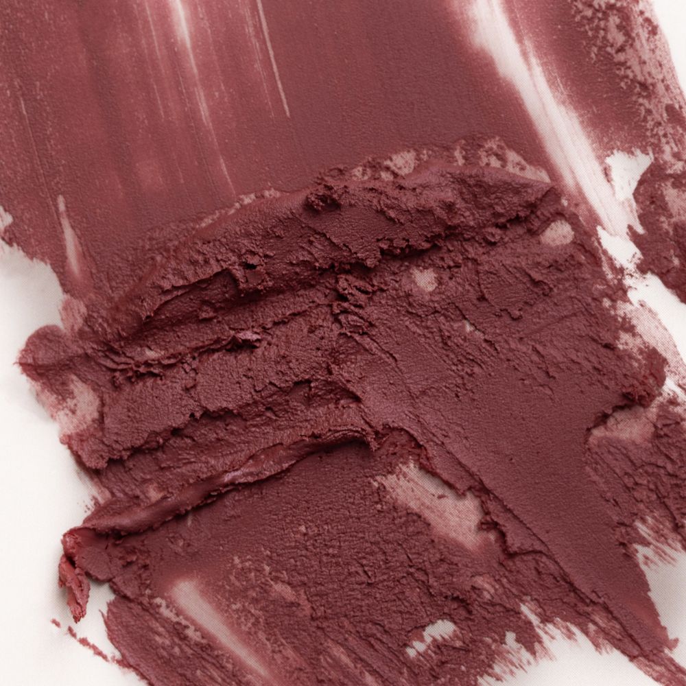 Primo piano di campioni di rossetto nude rose su sfondo bianco.