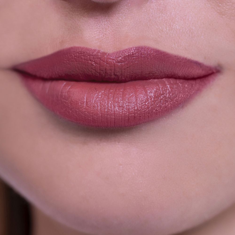 Primo piano di labbra truccate con rossetto nude rose.