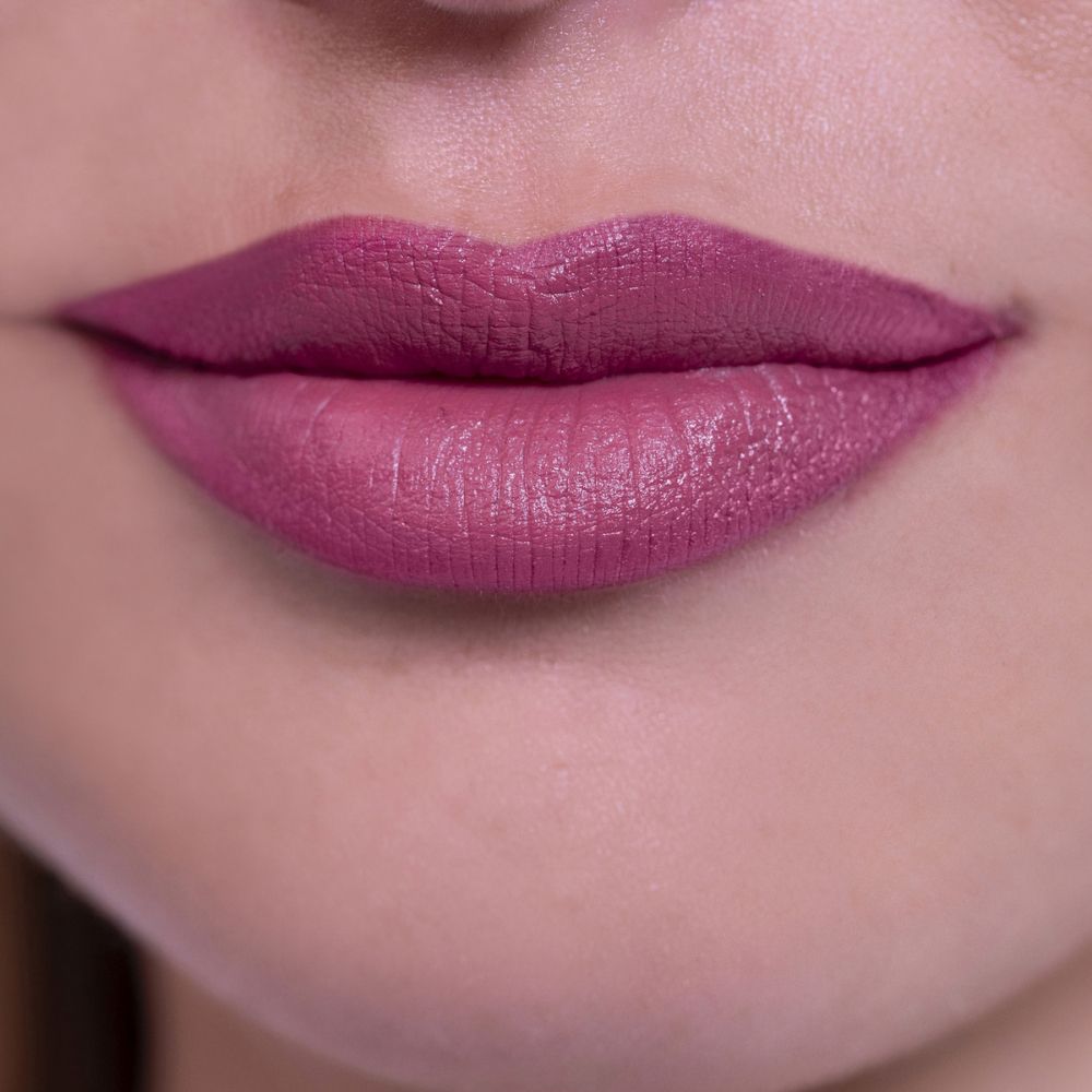 Primo piano di labbra coperte di rossetto rosa. Texture cremosa.