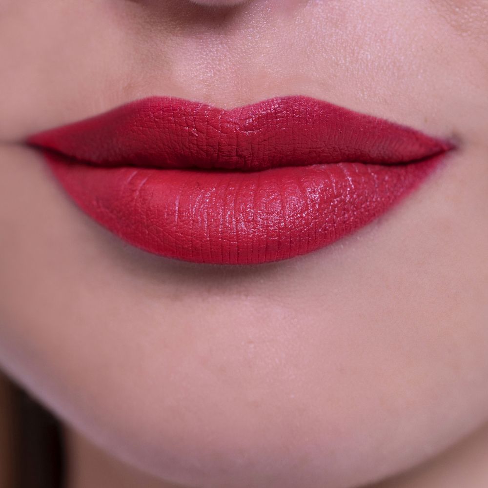 Primo piano di labbra truccate con rossetto rosso. Colore: rosso intenso.
