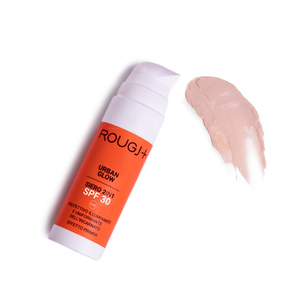 Flacone bianco con etichetta arancione. Testo: Rougj+, Urban Glow, Siero 2in1 SPF 30. Campione di prodotto.